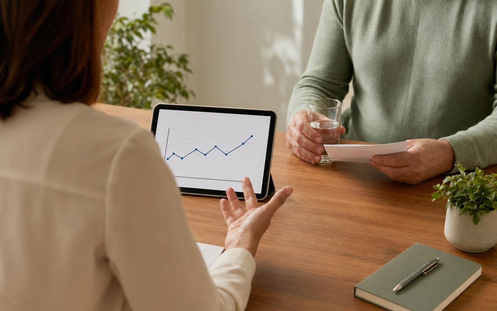 A coordinator and patient reviewing weight-loss treatment options together at a wood desk.