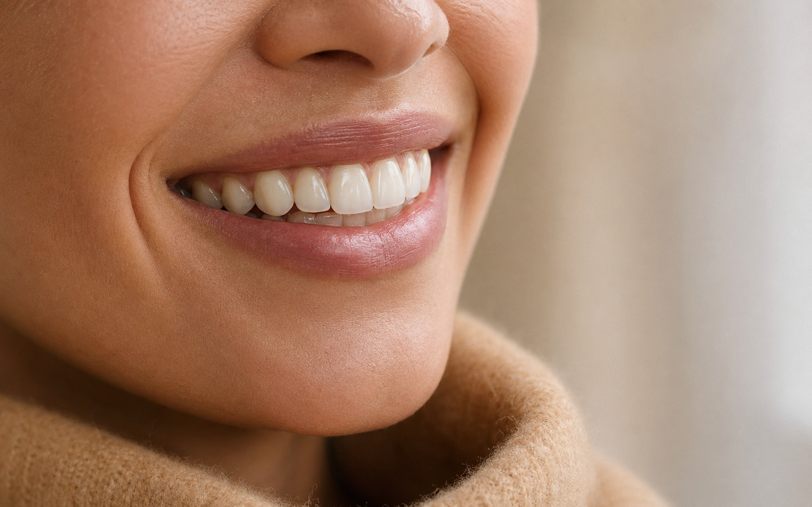 An editorial close-up of a refined porcelain veneer smile in soft natural daylight.