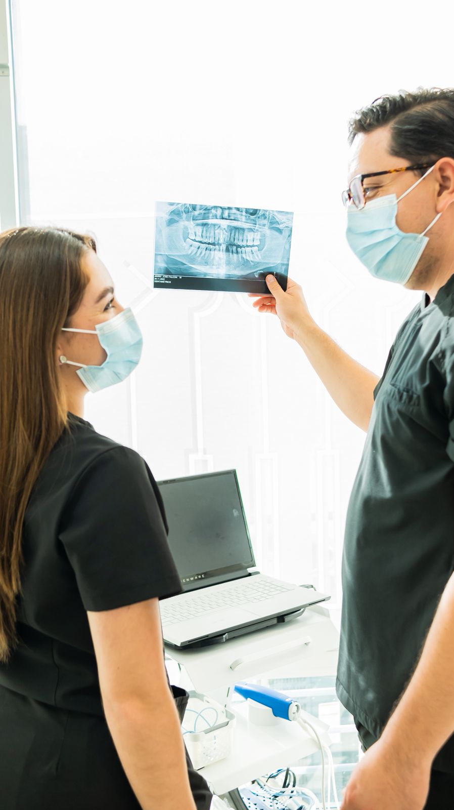 Two Allure Dental clinicians reviewing a panoramic X-ray together for restorative-dentistry treatment planning