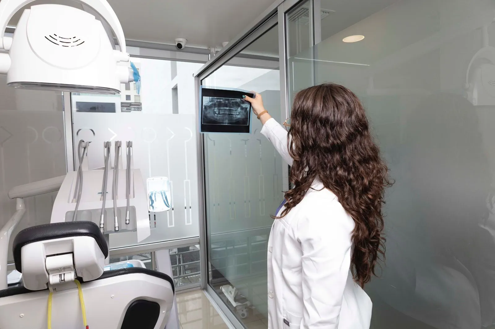 A dental specialist at the partner clinic in Tijuana reviewing a panoramic X-ray for treatment planning.