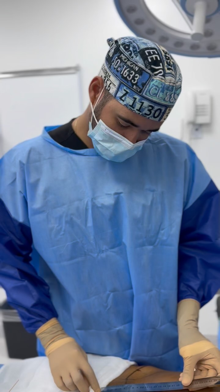 Dr. Luis Monta&ntilde;o working at the operating table during a facial procedure