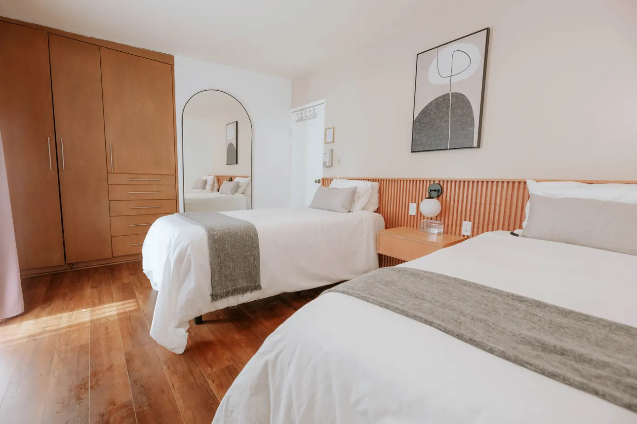 Recovery room with two beds, warm wood wardrobe and full-length mirror